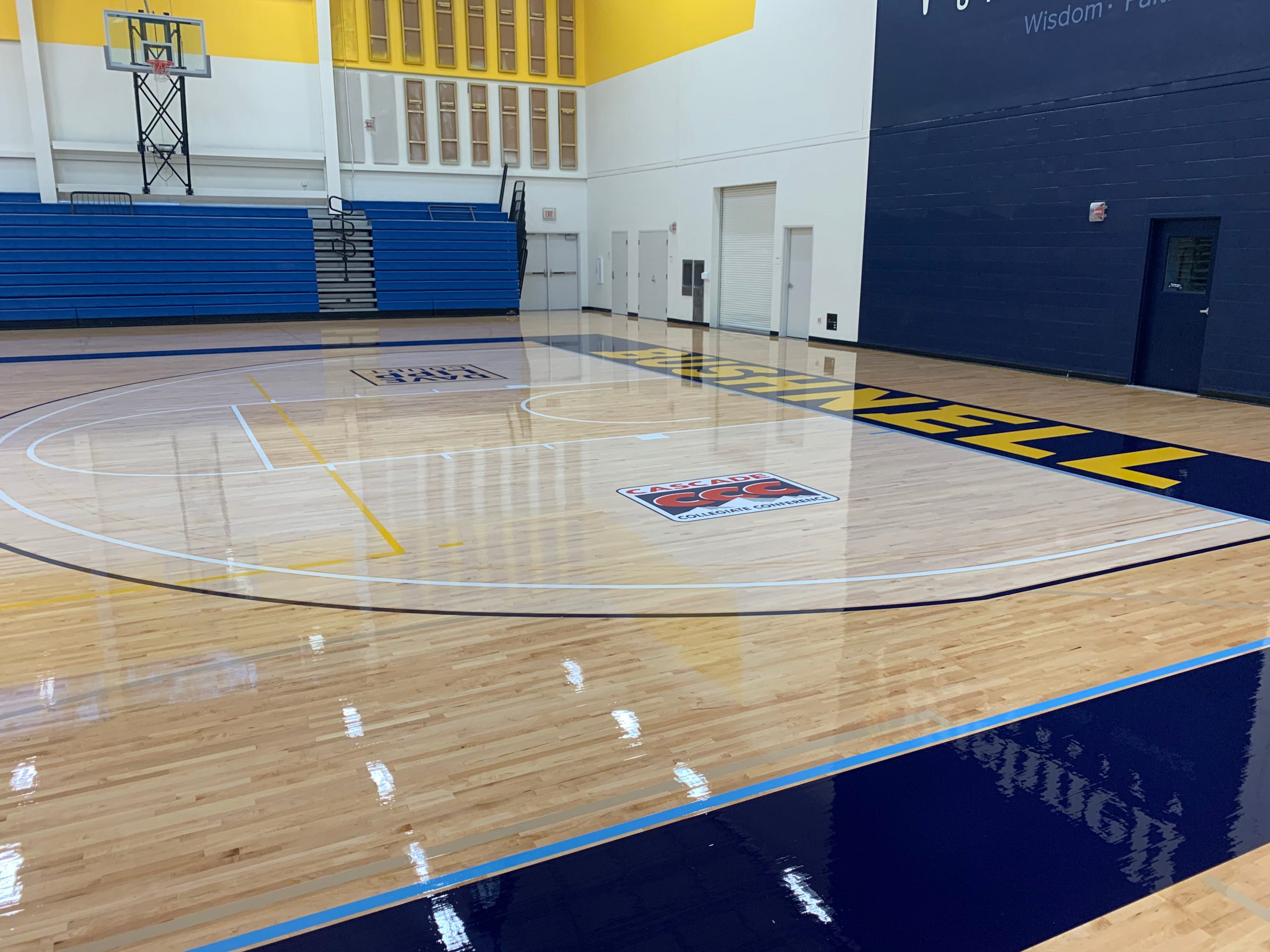 Bushnell University basketball court floor sanding and refinishing. Two coats of our oil-modified urethane sealer, paint game lines & logos, followed by two coats of glossy oil-modified urethane finish.