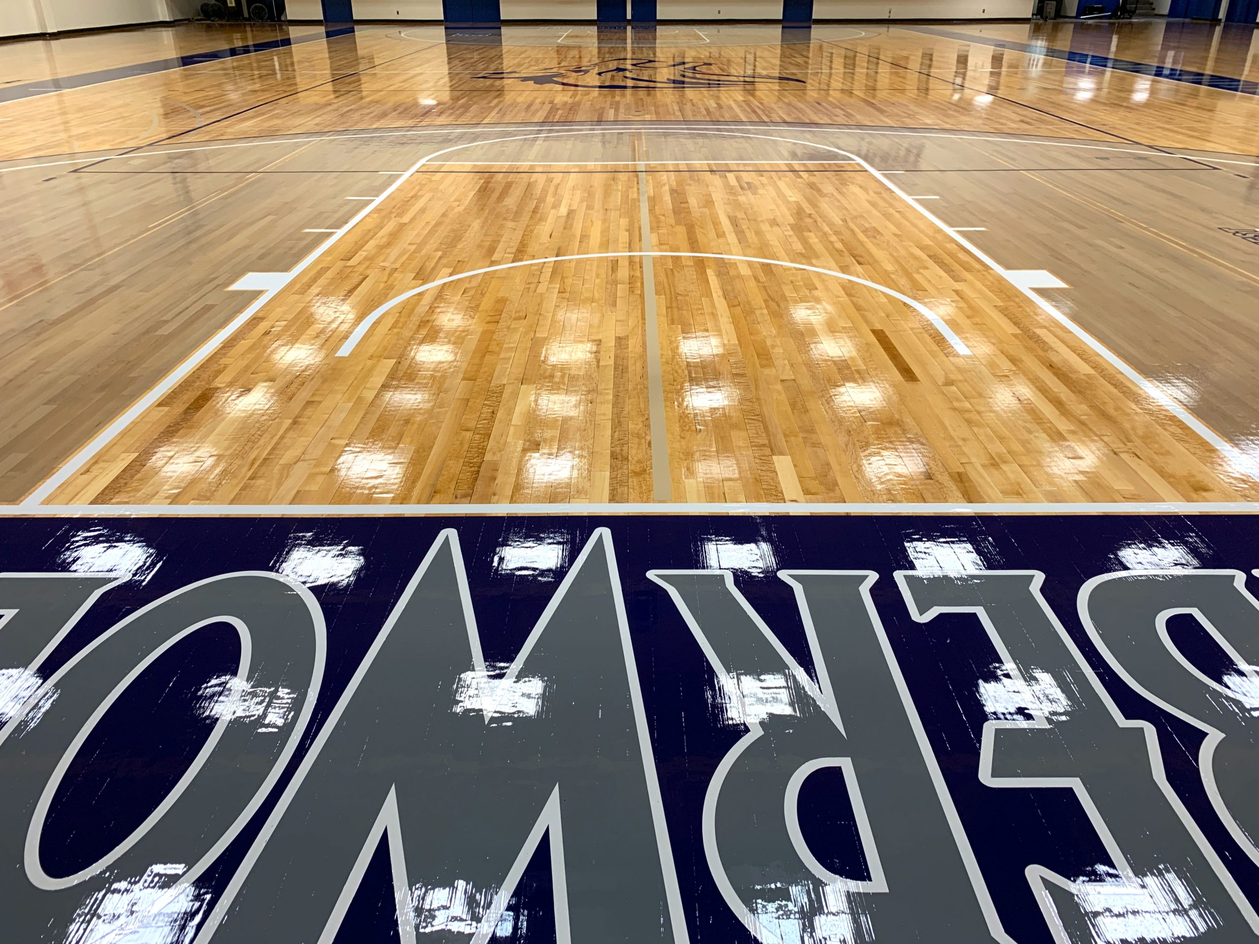 Blue Mountain Community College, Pendleton, Oregon - gym floor sanding & refinishing. Followed by sealing using our oil-modified urethane sealer, paint game lines and logos, and then two coats of Polydefender Gloss Finish.